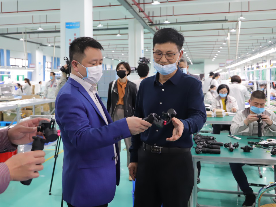 钟洪(左一)详细了解产品生产工艺